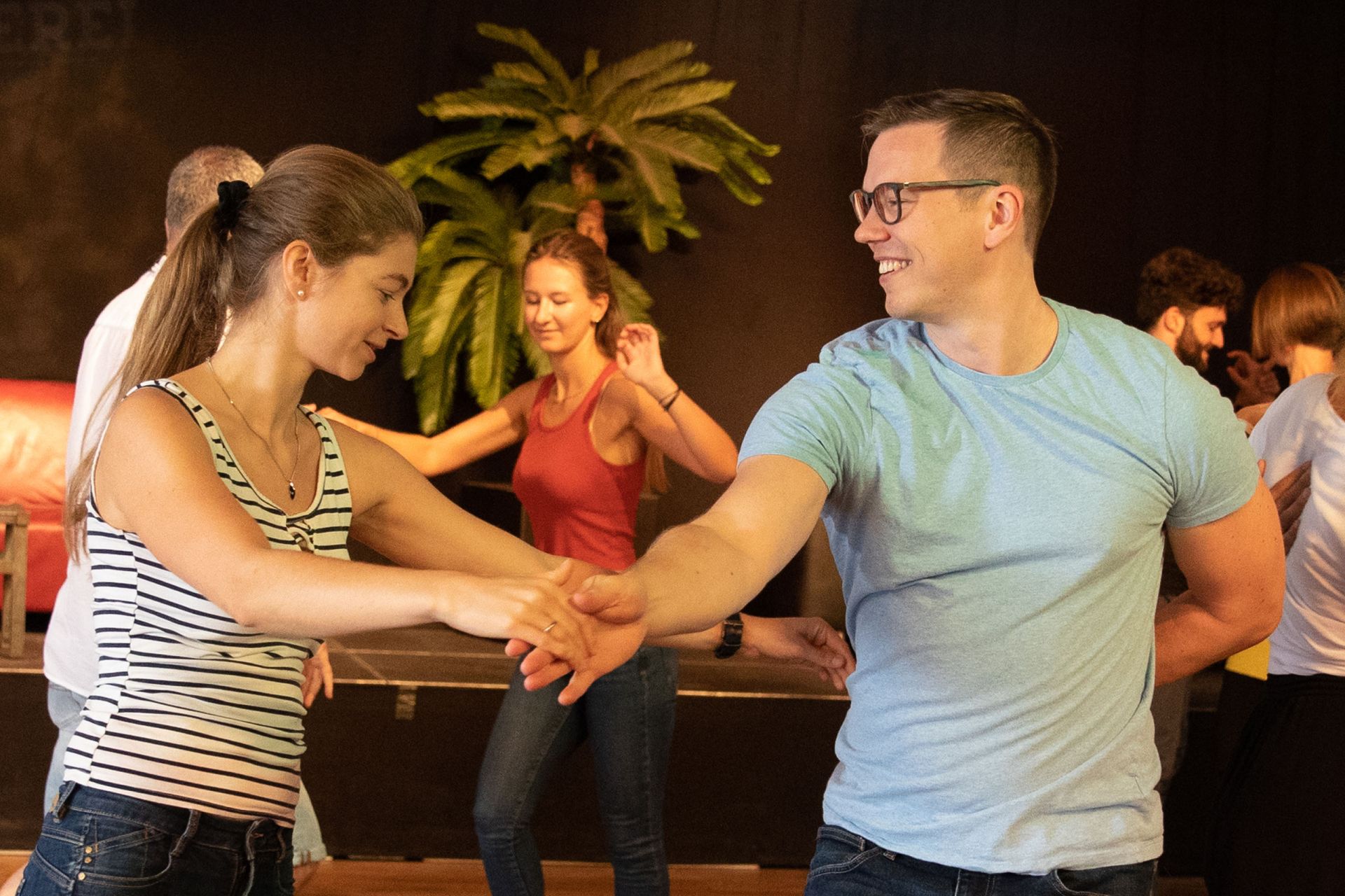 Mehrere Tanzpaare die Salsa tanzen in einem grossen Raum mit Tanzboden in Zürich