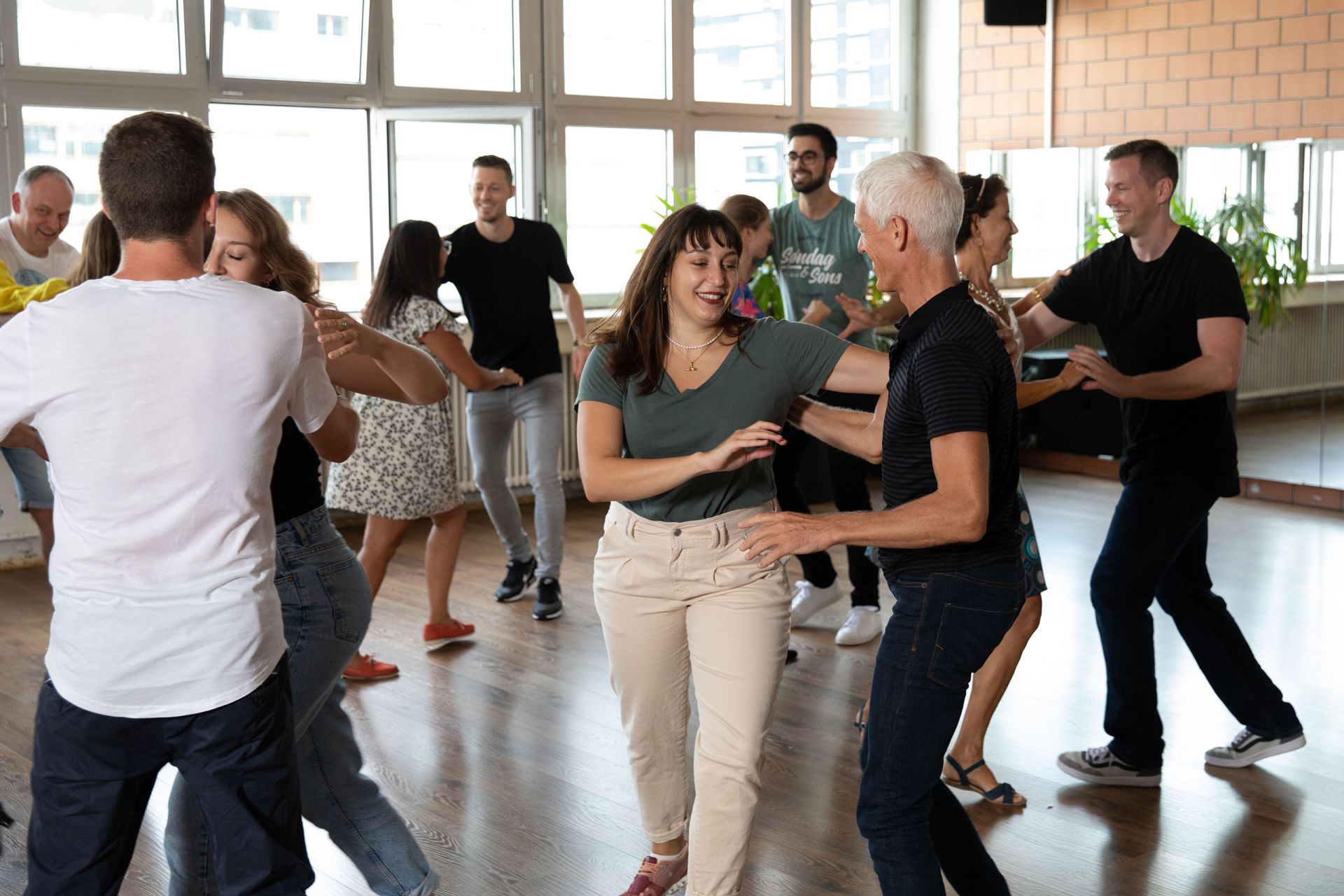Gruppe von Anfängerinnnen und Anfänger tanzen eine einfache Salsa-Figur
